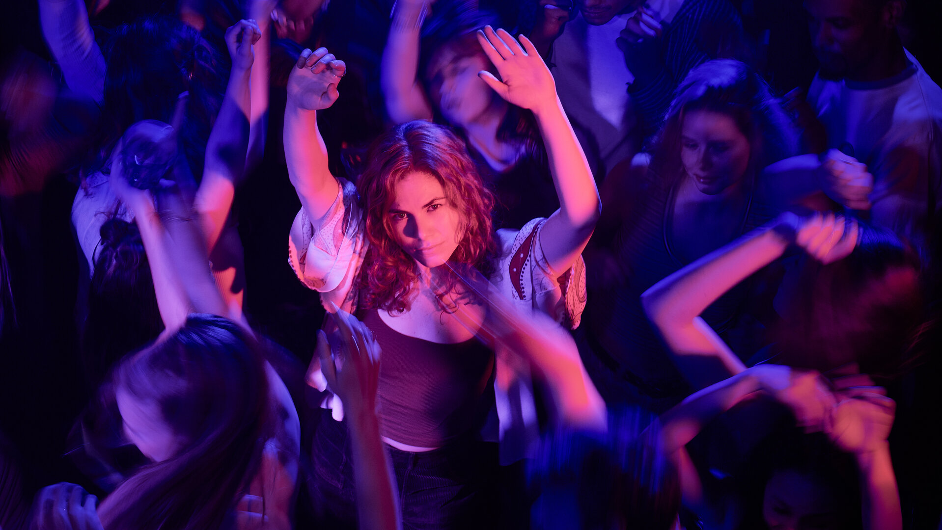"Don't Fall, Dance - Hier kommt Emma Maas": Emma (Hanna van Vliet) tanzt in einem bunt ausgeleuchteten Raum. Um sie herum sind weitere tanzende Menschen (Komparsen).