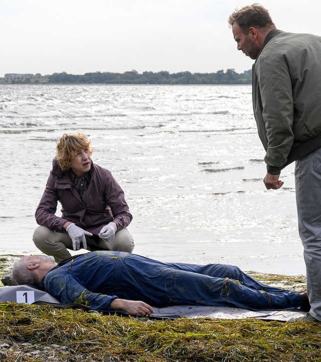 "SOKO Wismar – Tiefe Wasser": Mats Albers (Frank Leal-Soto) liegt tot am Strand. Dr. Helene Sturbeck (Katharina Blaschke), Lars Pöhlmann (Dominic Boeer) und Stefanie Horn (Nicole Ernst) haben sich um ihn versammelt.