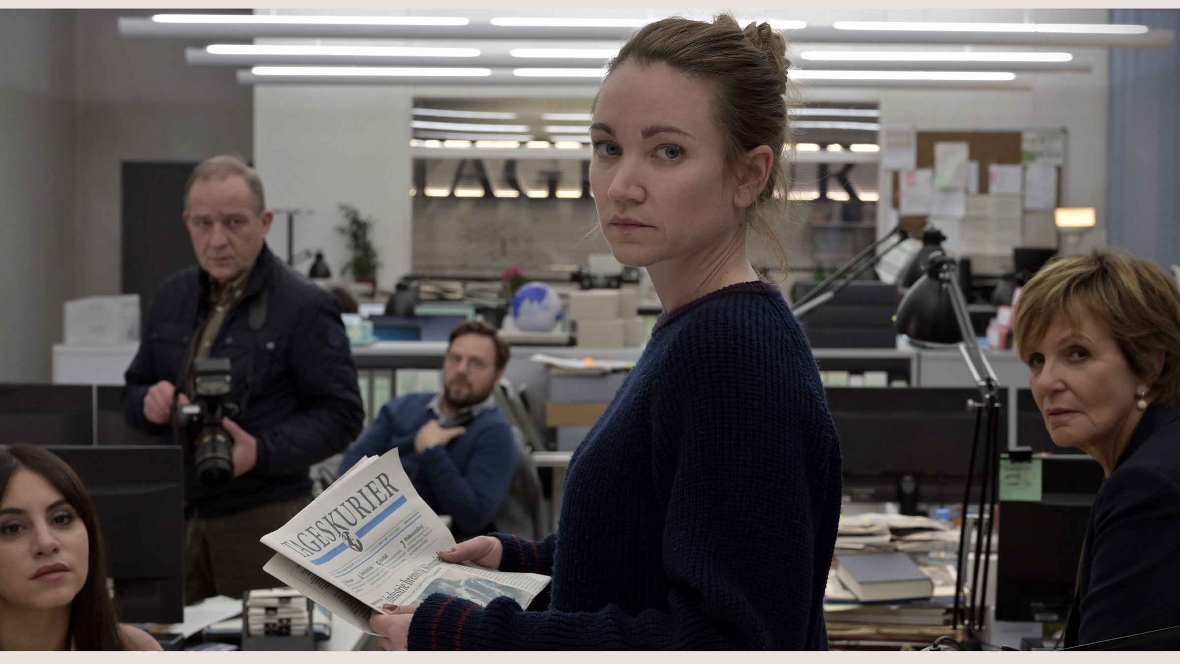 "Gefährliche Wahrheit": Blick in die Redaktionsräume des Tageskuriers. Die Mitarbeiter (Amila Bagriacik, Uwe Preuss, Christoph Letkowski, Ulrike Kriener) haben sich um ihre Kollegin Maren Gehrke (Lisa Maria Potthoff) versammelt. Sie hält eine Ausgabe der Zeitung in den Händen und blickt über die Schulter in Richtung der Kamera.