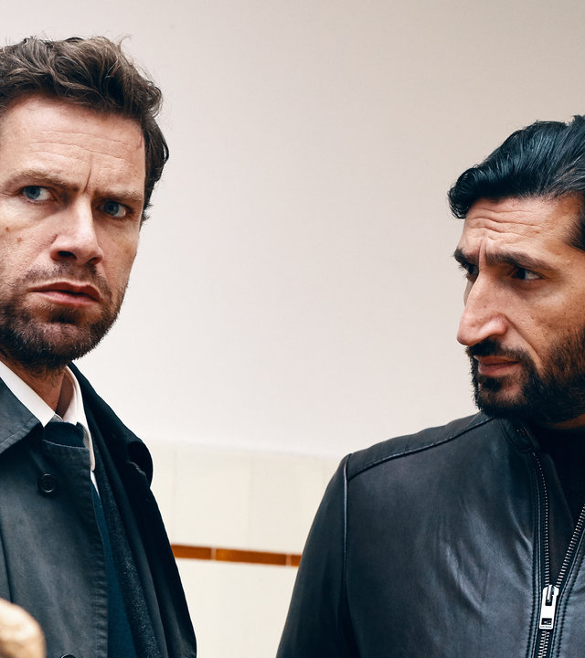 "Jussi Adler-Olsen: Verachtung": Assistent Assad (Fares Fares) steht neben Kommissar Carl Mørck (Nikolaj Lie Kaas) und sieht ihn an. Carl sieht nach vorn..