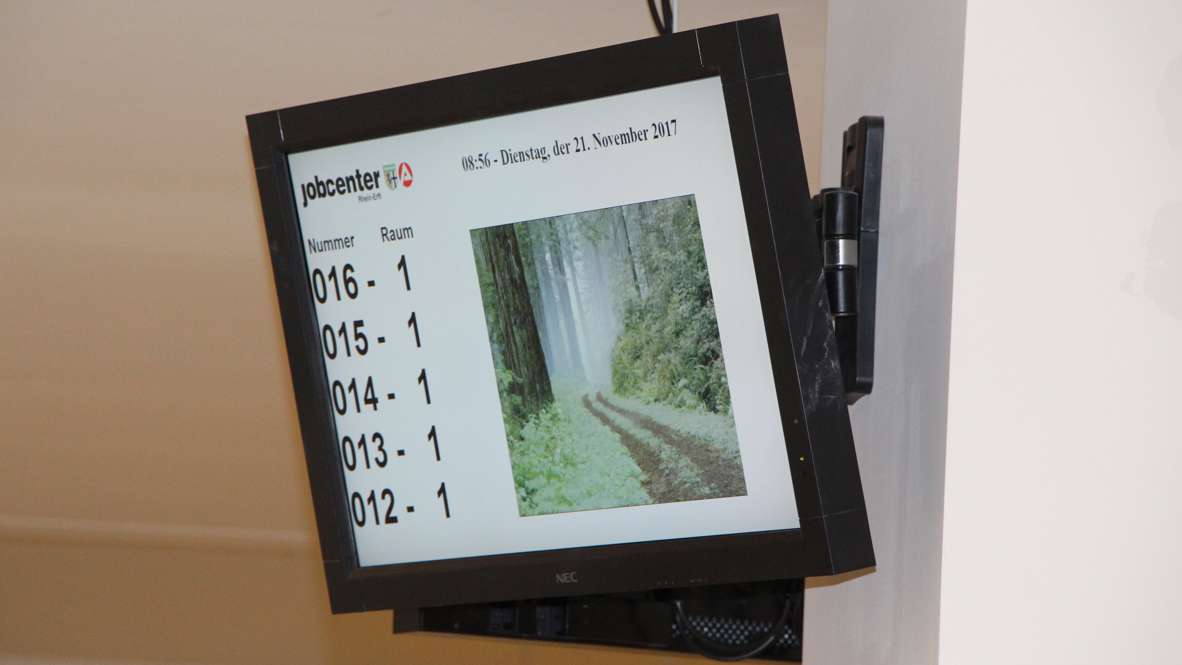 "ZDF.reportage: Deutschland, Deine Ämter - Die Berater vom Jobcenter": Ein Monitor zeigt die Nummern der Wartenden, die aufgerufen werden.