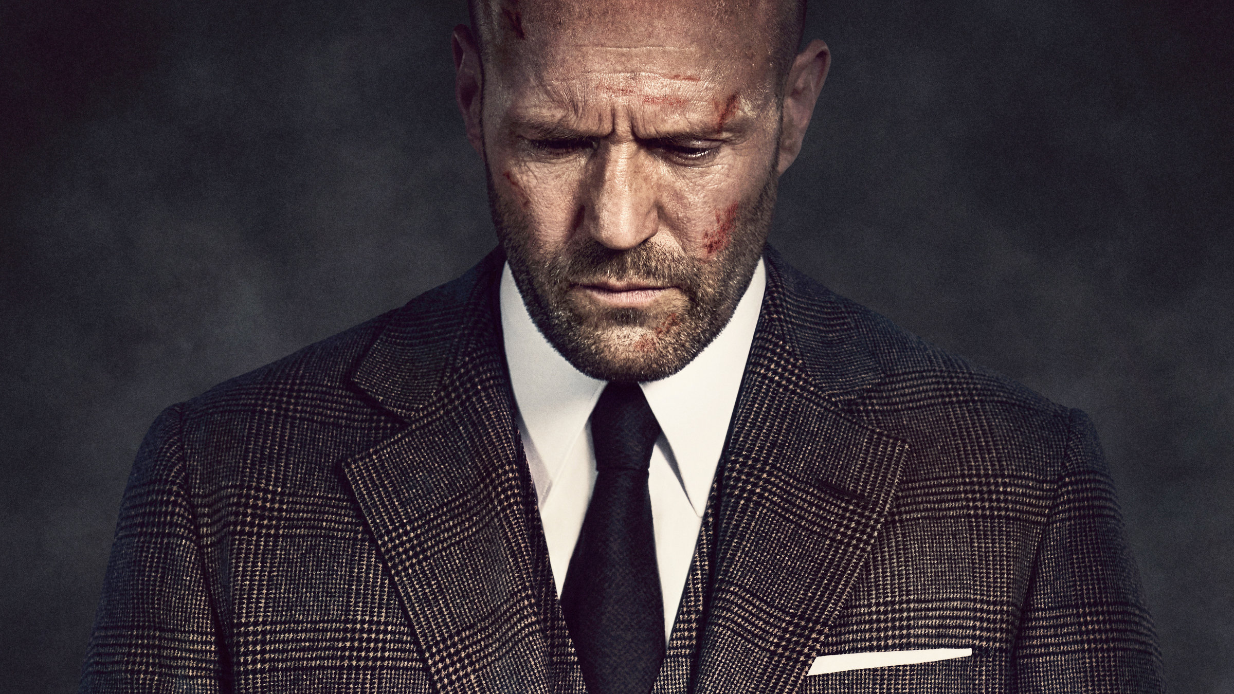 "Cash Truck": Porträtaufnahme: Mason Hargreaves alias Patrick Hill (Jason Statham) mit gesenktem Blick in Anzug