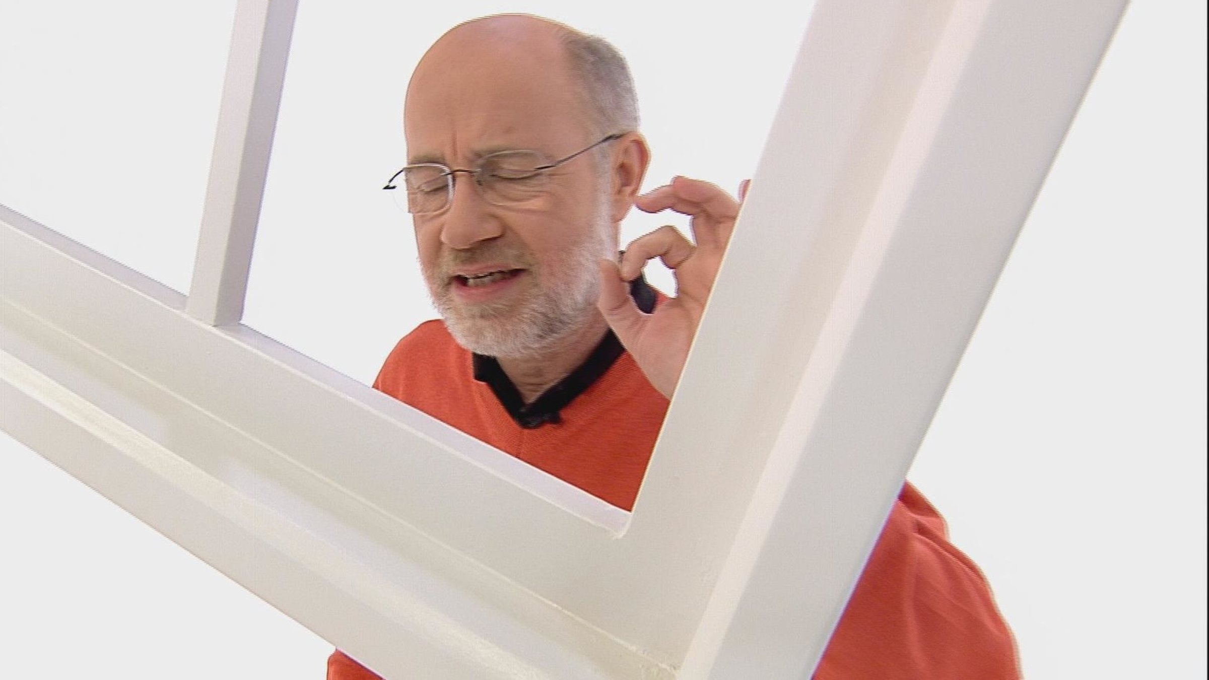 "Frag den Lesch: Mega-Explosion im Universum": Harald Lesch steht mit geschlossenen Augen hinter einem Fensterrahmen, der in der Luft hängt. Er macht eine nachdenkliche Pose.