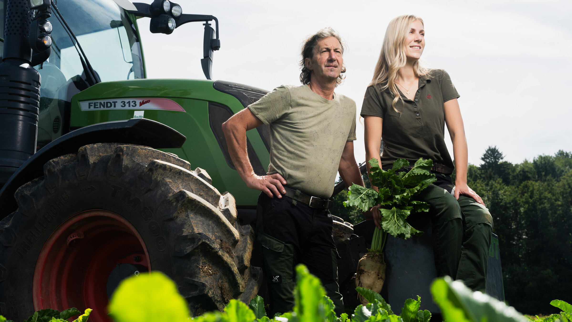 "ZDF.reportage: Mein Bauernhof, mein Leben - Ackern um jeden Preis?": Barbara Steinberger steht mit ihrem Vater Alfons Steinberger auf ihrem Zuckerrübenfeld vor einem Traktor.