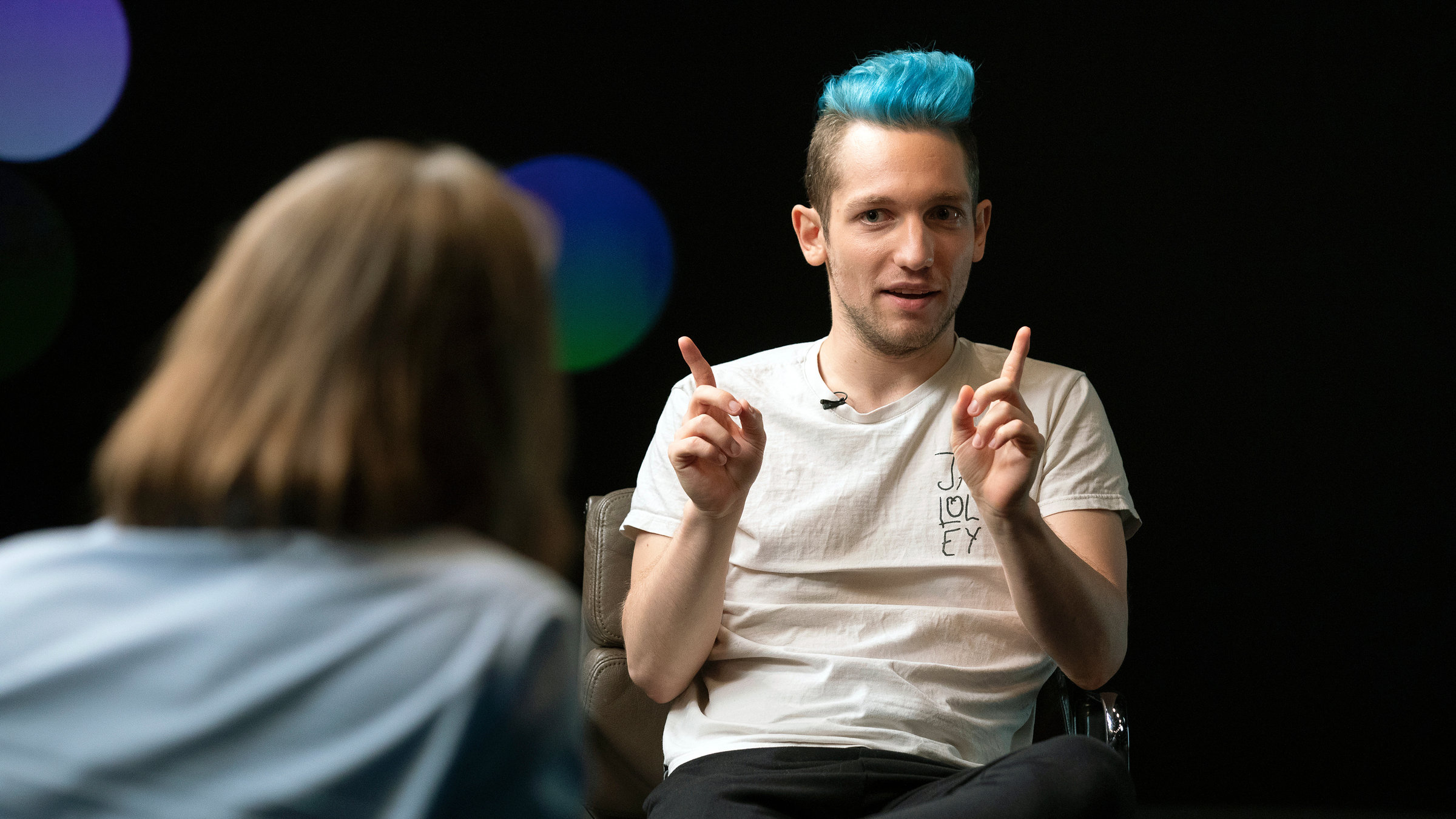 "Precht - Schöne neue Medienwelt - Wer hat die Meinungsmacht?": Moderator Richard David Precht mit dem Rücken zur Kamera sitzend im Gespräch mit Youtube-Star Rezo. Dieser hat eine blaue Haartolle und reckt die Zeigefinger der linken und rechten Hand nach oben.