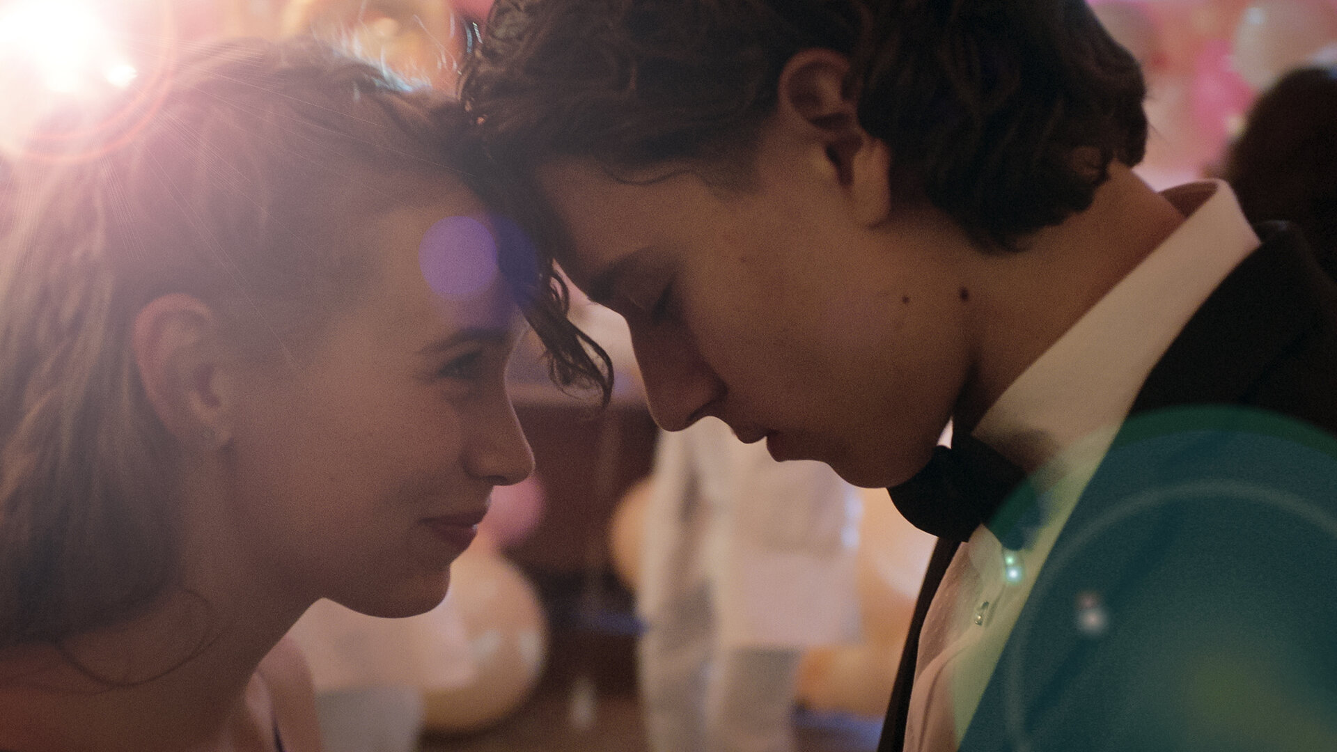 "Doktor Ballouz - Abschlussball": Juna (Lina Hüesker) blickt Ronni (Marven Gabriel Suarez-Brinkert) verliebt an. Die beiden haben ihre Köpfe aneinander gelegt.