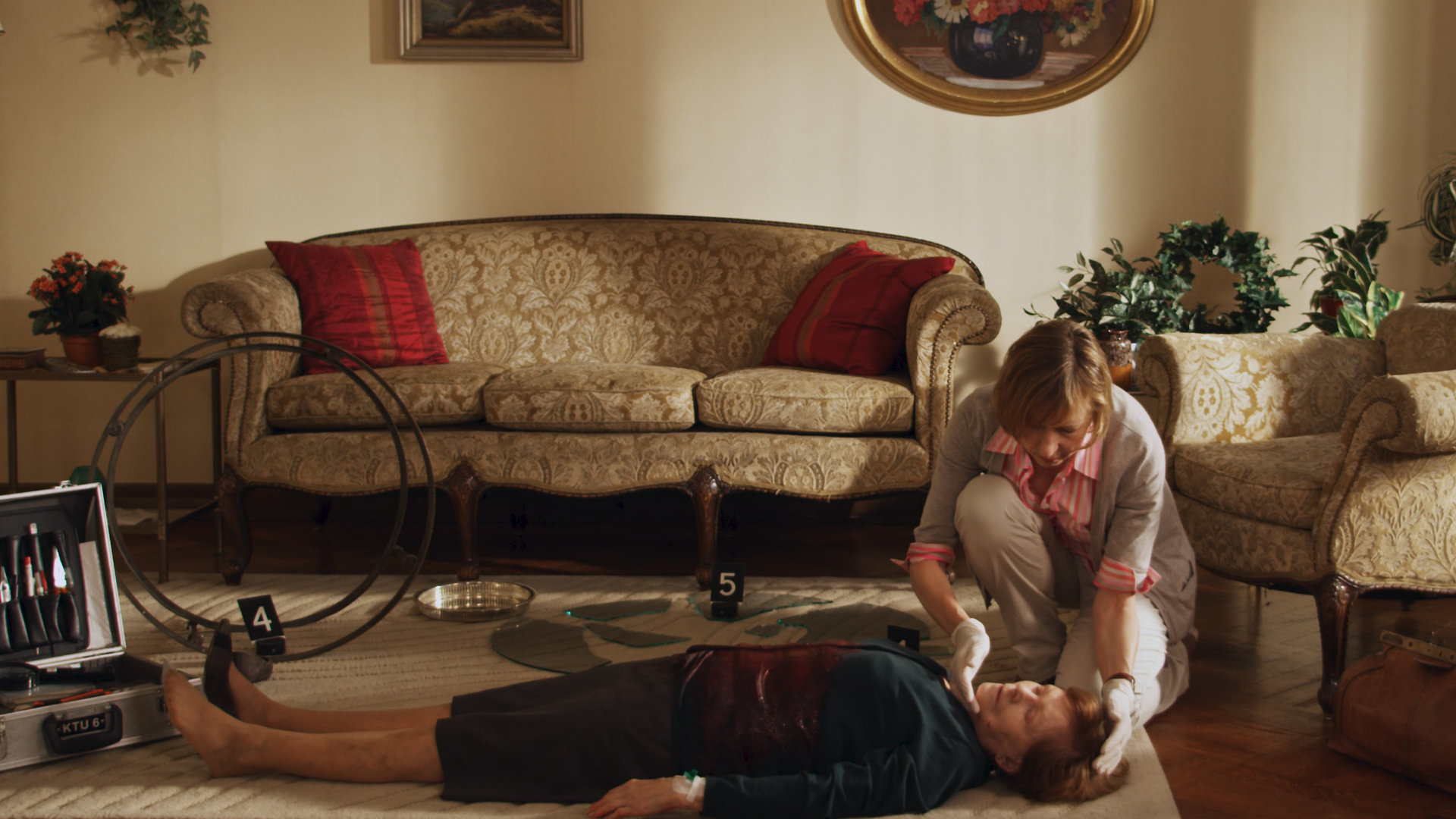 "SOKO Wismar - Barvermögen": In ihrem Wohnzimmer liegt Henriette Schäfer (Doris Abeßer) tot auf dem Boden. Helene Sturbeck (Katharina Blaschke) hockt neben der Leiche.