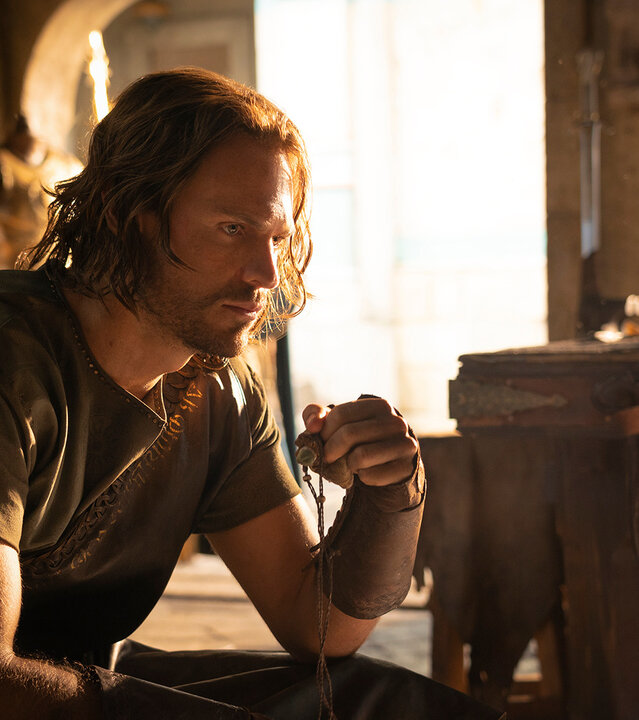 "Der Herr der Ringe: Die Ringe der Macht - Abschiede": Halbrand (Charlie Vickers) sitzt allein in einem Raum, der vom Tageslicht erleuchtet ist. Er wirkt nachdenklich.