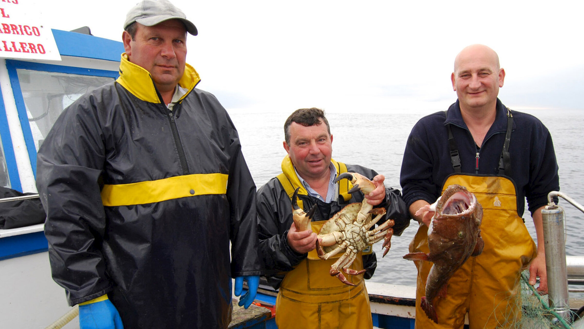 "Zu Tisch in ...Asturien": Salvador Fernández (ganz rechts) mit Kollegen auf seinem Fischerboot. Er hält einen Seeteufel in den Händen.