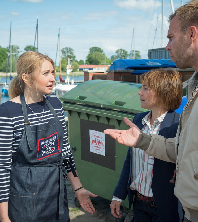 „SOKO Wismar – Die Kante von Wismar“: Katrin Börensen (Claudia Schmutzler) und Lars Pöhlmann (Dominic Boeer) sprechen mit Nadja Reisinger (Malina Ebert) hinter dem Hafencafé.