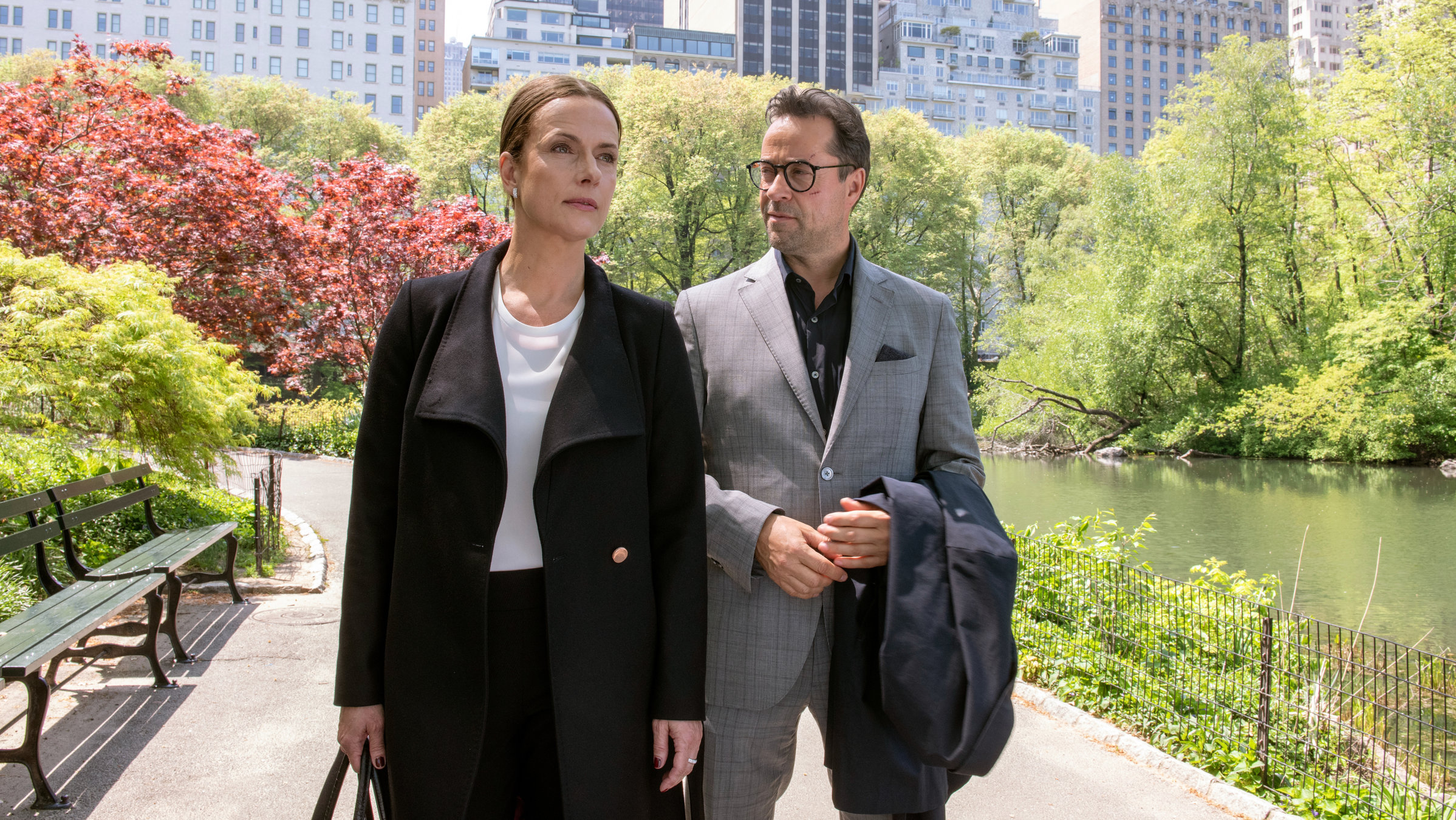 "Totengebet": Rebecca (Claudia Michelsen) und Joachim Vernau (Jan Josef Liefers) laufen nebeneinander durch einen Park. Im Hintergrund sieht man Hochhäuser.