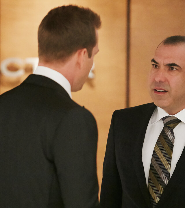 "Suits - Keine Frage des Geldes": Louis (Rick Hoffmann) und Harvey (Gabriel Macht) stehen sich im Flur der Kanzlei gegenüber. Louis schaut Harvey wütend an. Harvey steht mit dem Rücken zur Kamera.