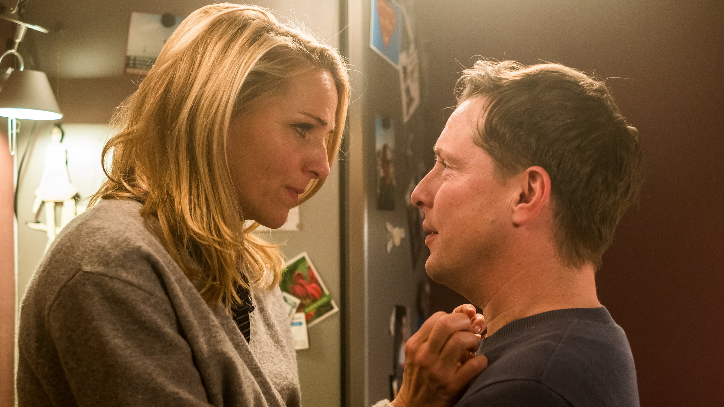 "Fritzie - Der Himmel muss warten - Krieg und Frieden": Zu Hause in ihrer Küche sind sich Fritzie (Tanja Wedhorn) und Stefan (Florian Panzner) gegenüber, schauen sich innig in die Augen und berühren einander dabei vertraut.