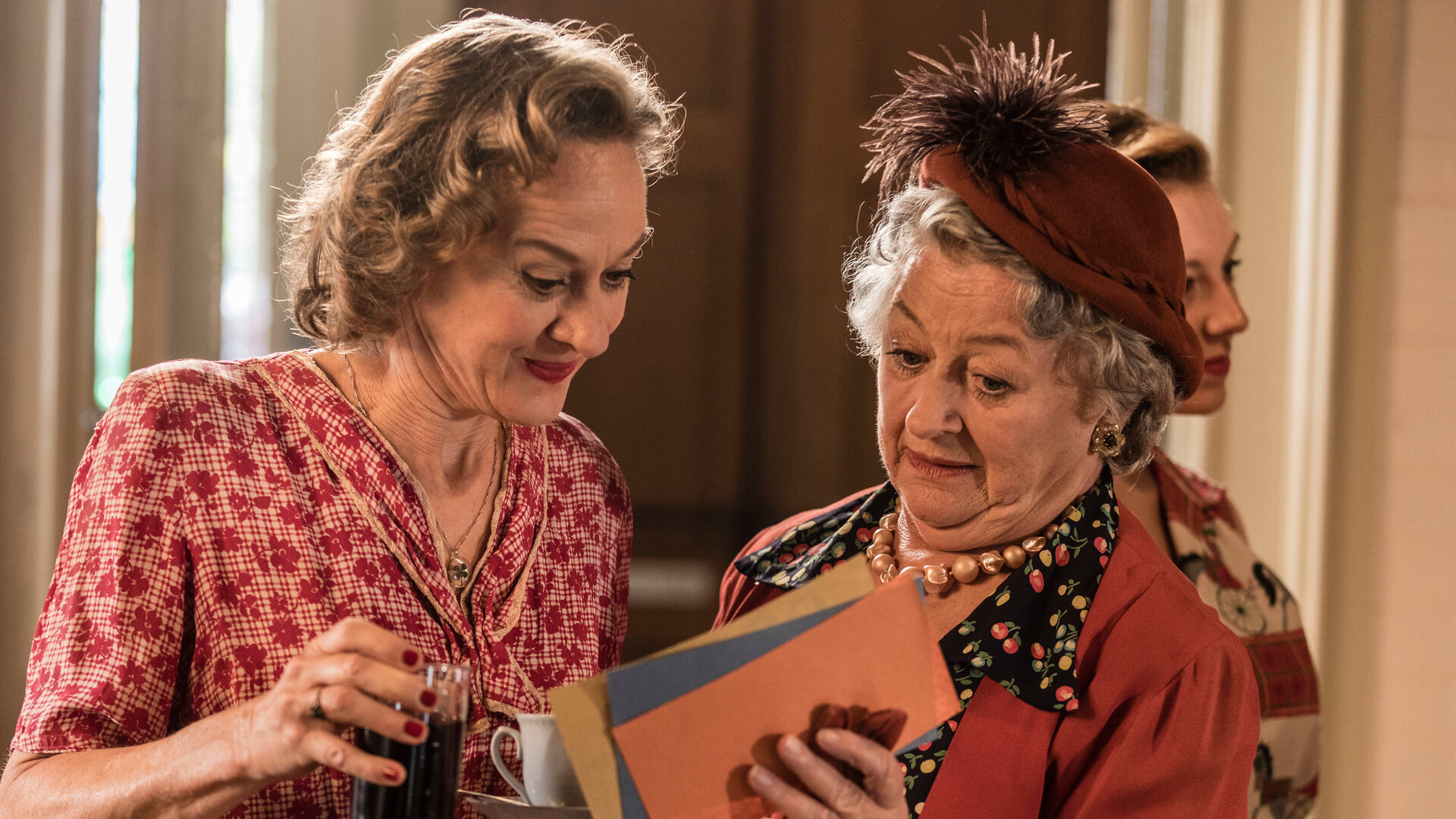 "Father Brown - Die Zahlen des Teufels": Mrs. McCarthy (Sorcha Cusack) und ihre Schwester Roisin Crayford (Niamh Cusack) betrachten die Lose, die sie beim Bingo-Spiel erhalten haben.