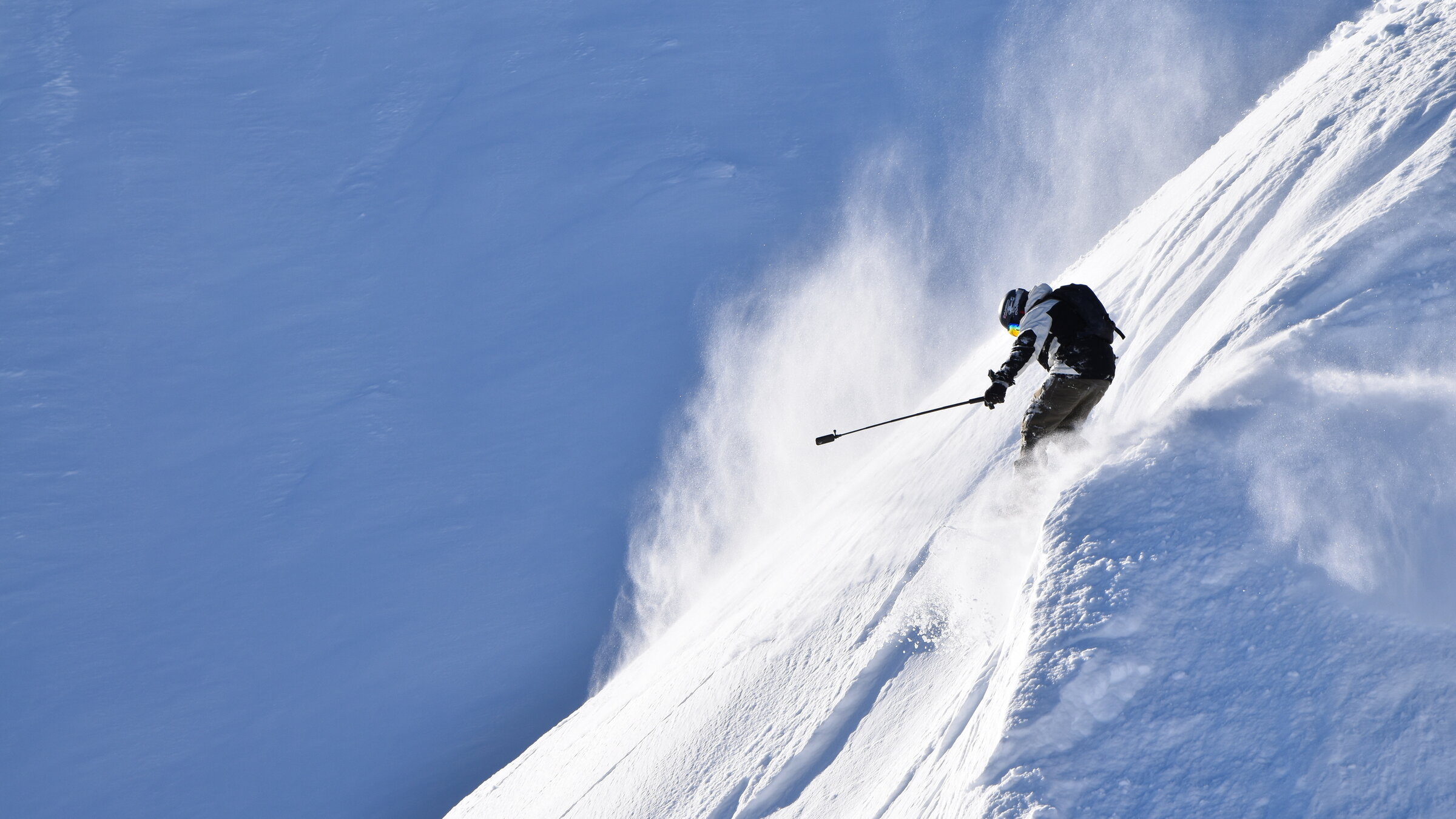 "ZDF.reportage: Hauptsache Schnee! - Berge, Ski und Hüttenzauber":  Ein einsamer Wintersportler im Tiefschnee bei Sonnenschein