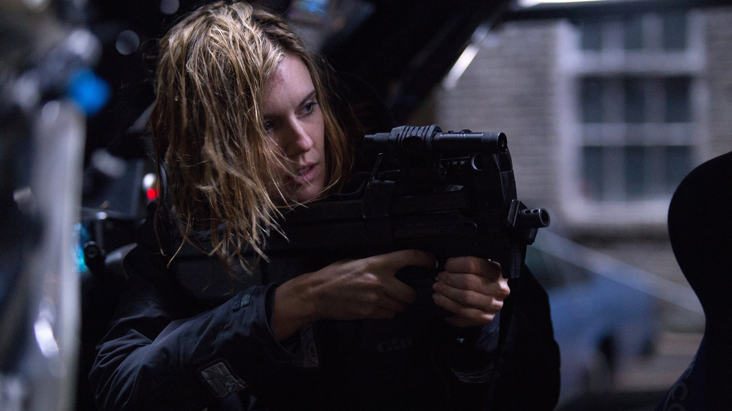 "Im Auge des Hurrikans": Casey (Maggie Grace) hat nasse Haare und zielt mit einer Waffe auf etwas außerhalb des Bildes.