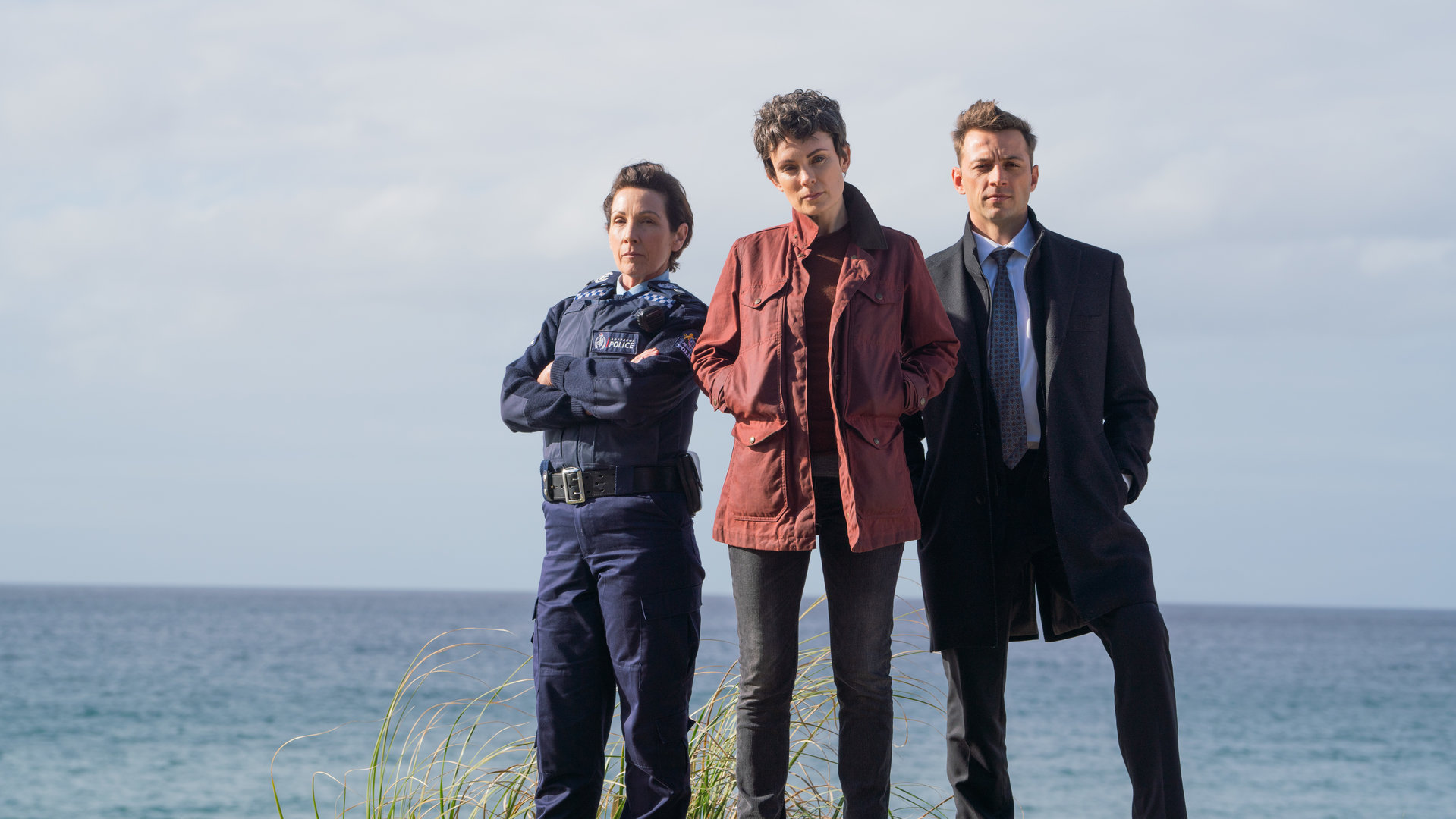 "Auckland Detectives - Tödliche Bucht: Entführung": Detective Senior Sergeant Jessica Savage (Kate Elliott), ihr Kollege Detective Sergeant Justin Harding (Ido Drent) und Senior Sergeant Denise Abernethy (Alison Bruce) in Nahaufnahme am Strand von Waiheke.