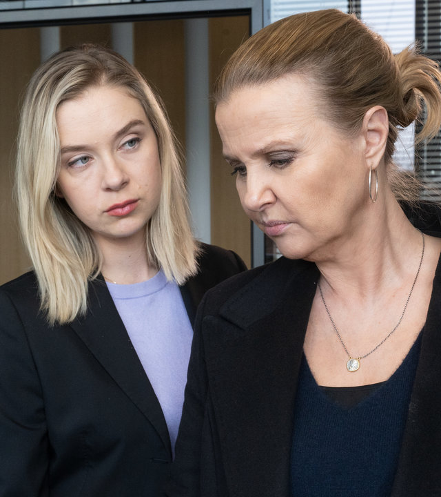 "Die Chefin - Fake News": Tanja Meineke (Anna Herrmann) sieht Vera Lanz (Katharina Böhm) von der Seite an, während Lanz mit Gummihandschuh ein Papier in der Hand hält. Sie befinden sich in einem Büroraum.