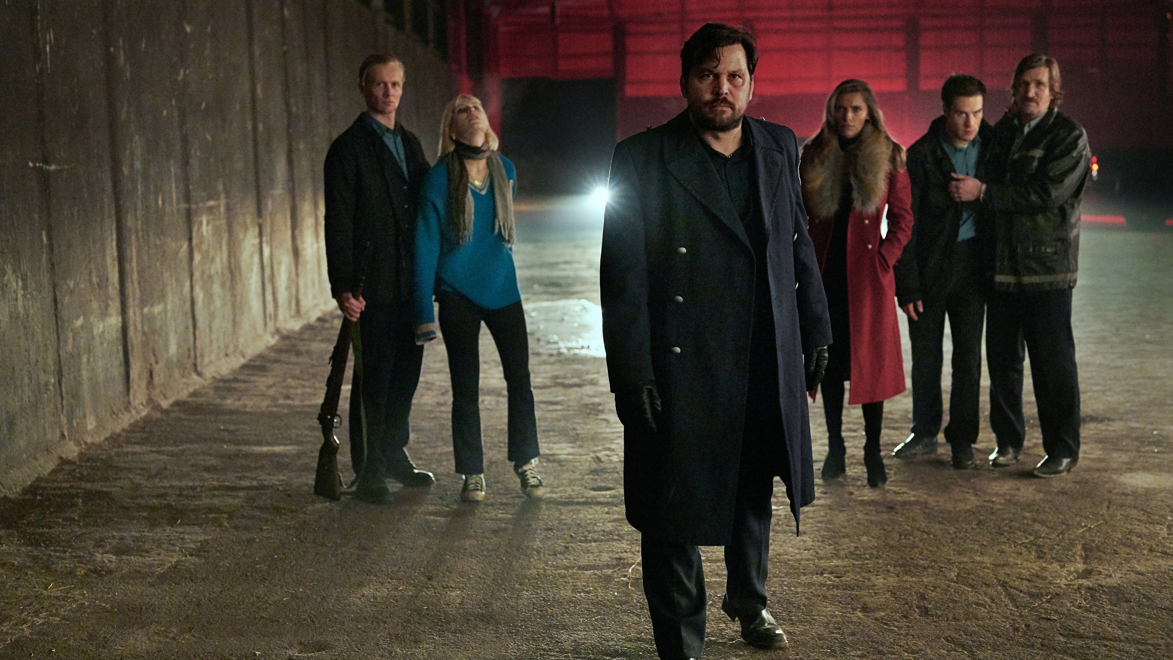 "Wir können nicht anders": Herrmann (Sascha Alexander Geršak) in leerstehender Fabrikhalle mit Thoralf (Roman Schomburg), der Edda (Alli Neumann) festhält, links hinter ihm und Katja (Sophia Thomalla), Ronny (Malte Thomsen) und Norbert (Karsten Mielke) rechts hinter ihm.