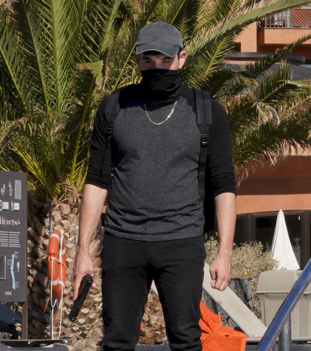 "Crossfire - Tod in der Sonne (1)": Attentäter Flavio (Pol Sanuy) steht vermummt mit einer Waffe in der Hand vor dem Pool.