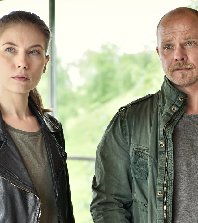 "Die Toten vom Bodensee - Der Wegspuk": Die Kommissare Micha Oberländer (Matthias Koeberlin) und Hannah Zeiler (Nora Waldstätten) stehen nebeneinander vor einem Fenster.