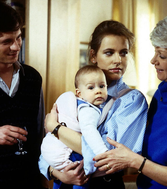 "Die Wicherts von nebenan: Ratschläge einer Freundin": Rüdiger (Jochen Schroeder) und Uschi (Anja Schüte) stehen neben Hannelore (Maria Sebaldt) und blicken zu ihr. Diese berührt das Baby, das Uschi auf dem Arm hält.