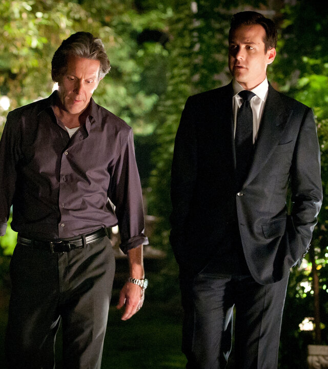 "Suits - Spielregeln": Harvey (Gabriel Macht) und Cameron Dennis (Gary Cole) gehen nebeneinander einen nächtlich beleuchteten Weg entlang. Während Harvey den Blick zur Seite richtet, schaut Cameron nach unten – beide wirken ernst.