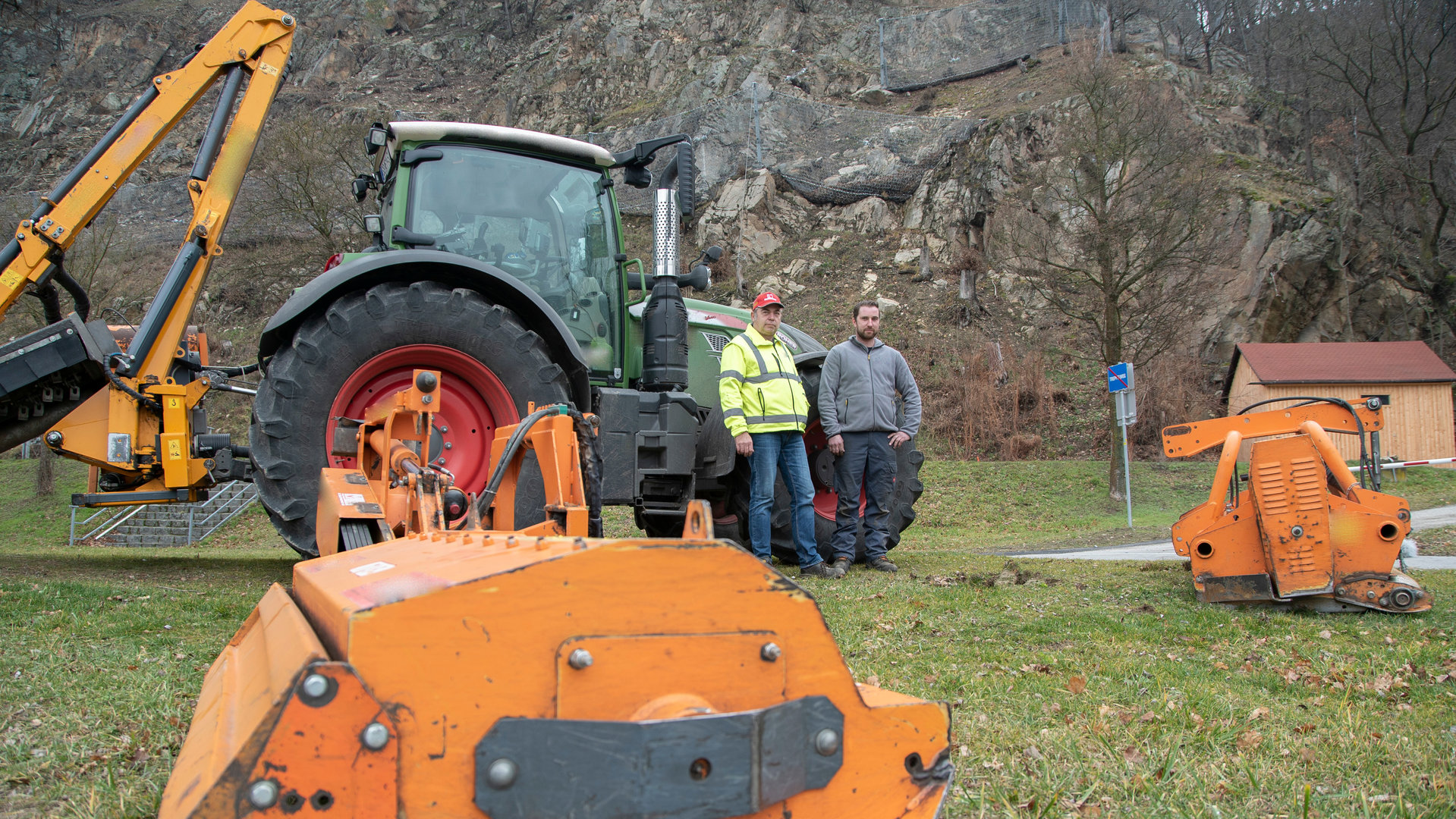 "Terra Xpress: Dreiste Traktorbande und nervige Nachbarn": Zwei Männer stehen vor ihrem Traktor auf einer Wiese.