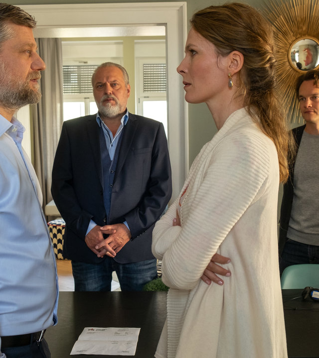 "Der Alte - Trügerische Liebe": André Wegmann (Andreas Guenther) und Barbara Wegmann (Katrin Bühring) stehen sich gegenüber. Er blickt sie fordernd an, während sie mit vor dem Körper verschränkten Armen vor André steht. Richard Voss (Jan-Gregor Kremp) und Tom Kupfer (Ludwig Blochberger) beobachten das Geschehen aus dem Hintergrund.