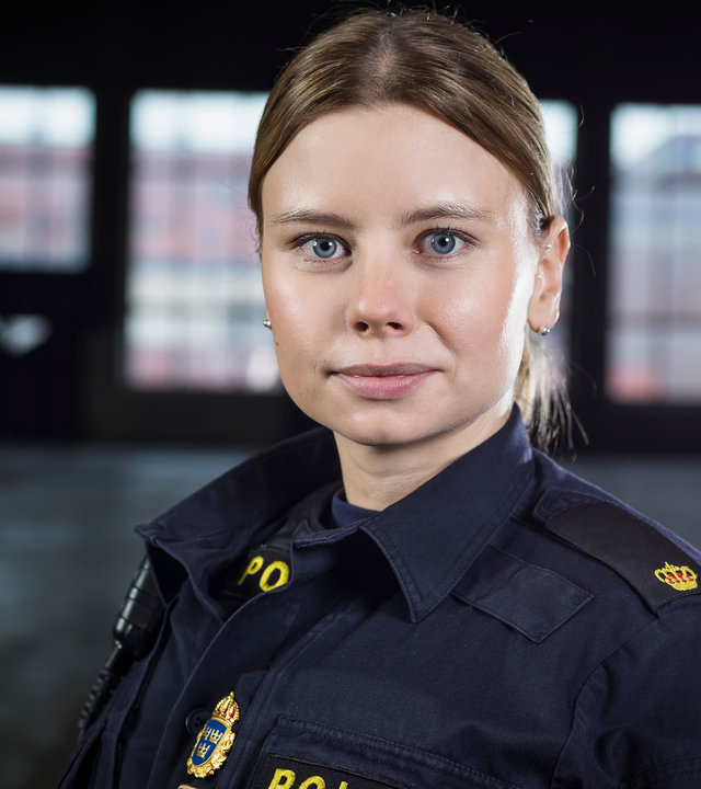 "Thin Blue Line - Ankunft": Sara (Amanda Jansson) steht in einem dunklem Raum und schaut konzentriert in Richtung Kamera.