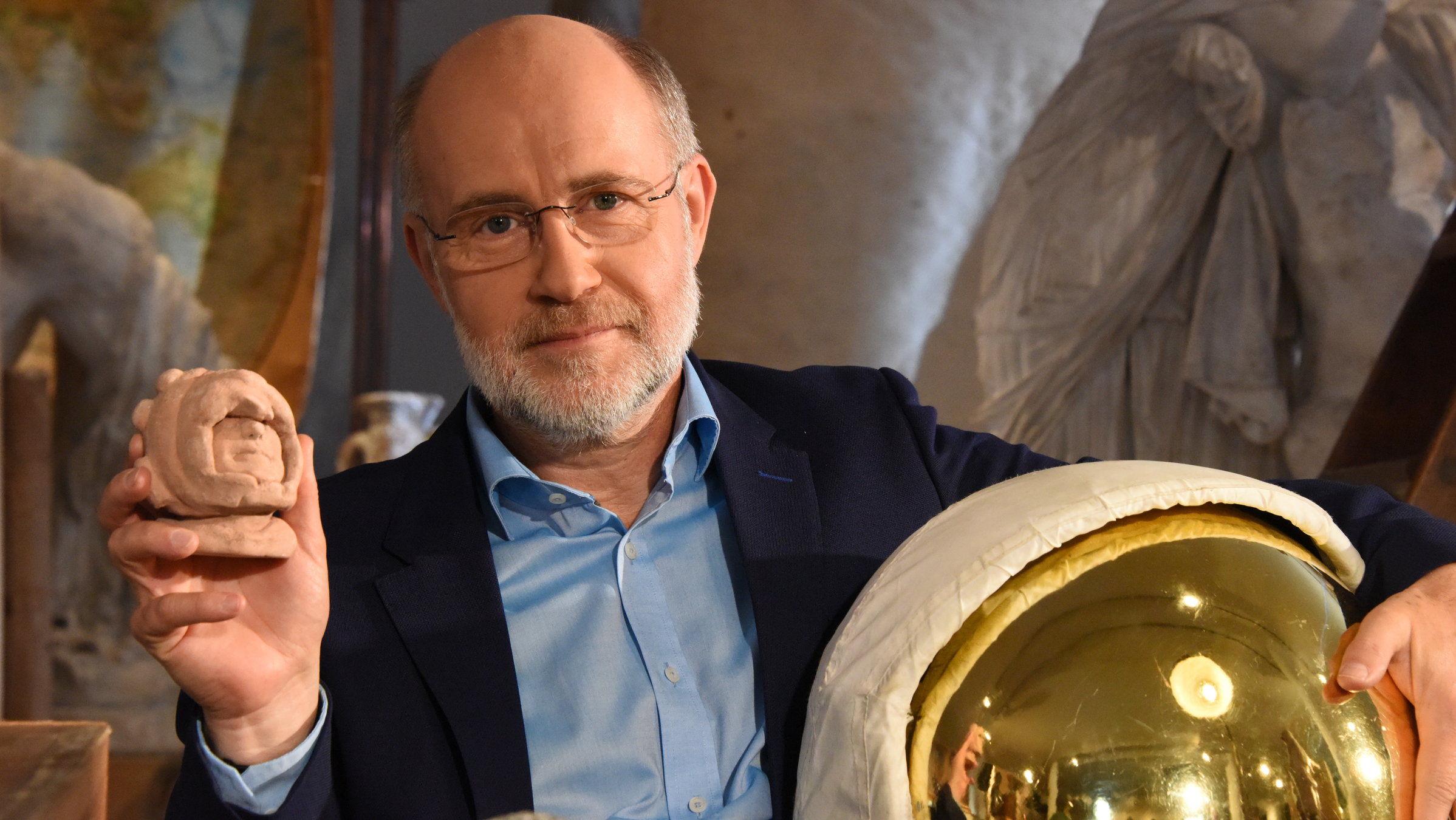 "Terra X: Ungelöste Fälle der Archäologie - Brisante Funde": Harald Lesch hält in der einen Hand ein kleine Maya-Skulptur und in der anderen eine Art Taucherhelm.