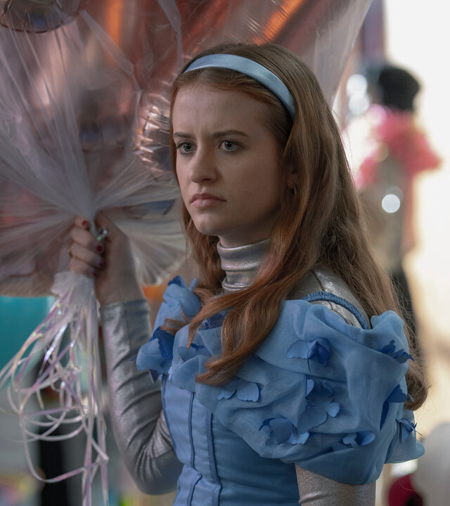 "Extraordinary - Habenichtse": Jen (Máiréad Tyers) steht grimmig blickend in einem Geschäft. In ihrer Hand hält sie ein Strauß Helium-Luftballons.