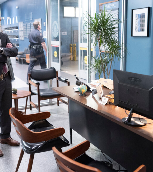 "The Rookie - Druck": Dr. London (Danielle Campbell) und Detective Pearson (Daniel Bonjour) stehen in einem Büro vor Sergeant Grey (Richard T. Jones), der an seinem Schreibtisch sitzt und sie mit skeptischem Blick mustert.