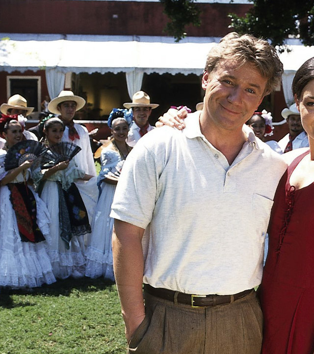 "Das Traumschiff - Mexiko": Dr. Andreas Brauer (Jörg Schüttauf) steht Arm in Arm mit Corinna (Marion Mitterhammer) auf einer Wiese. Hinter ihnen steht eine argentinische Folkloregruppe.