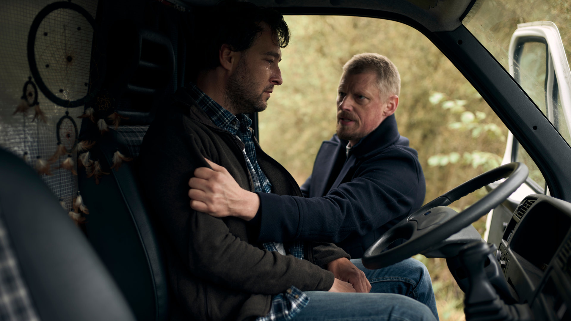 "SOKO Wien - Letzte Ausfahrt Hoffnung": In einem Camper sitzt Dominic Haller (Clemens Berndorff) am Steuer. Neben ihm, an der geöffneten Fahrertür, steht Major Max Herzog (Martin Gruber). Dieser packt Dominic Haller am rechten Jackenärmel.