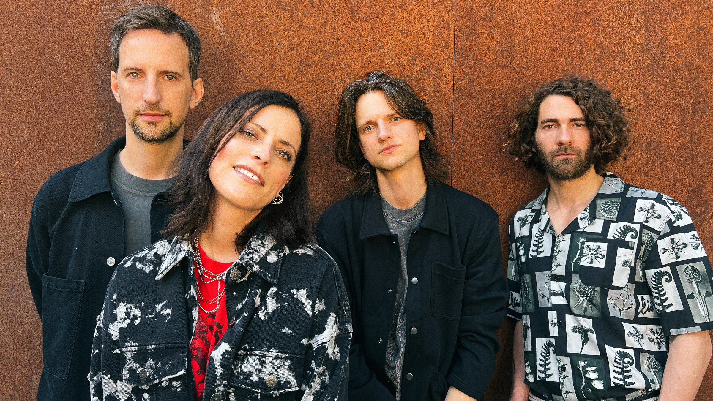 "Silbermond: Auf Auf - Live im Theater des Westens, Berlin": Die vier Bandmitglieder stehen vor einer braunen Wand und blicken in die Kamera.