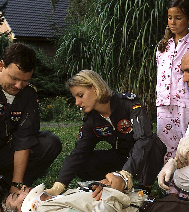 "Die Rettungsflieger - Voller Überraschungen": Thomas Asmus (Ulrich Bähnk) und Sabine Petersen (Marlene Marlow) versorgen den verletzten Pitter Schrankel (Dietrich Adam), der vor ihnen auf einer Trage liegt. Daneben steht seine Tochter (Julina Senol).