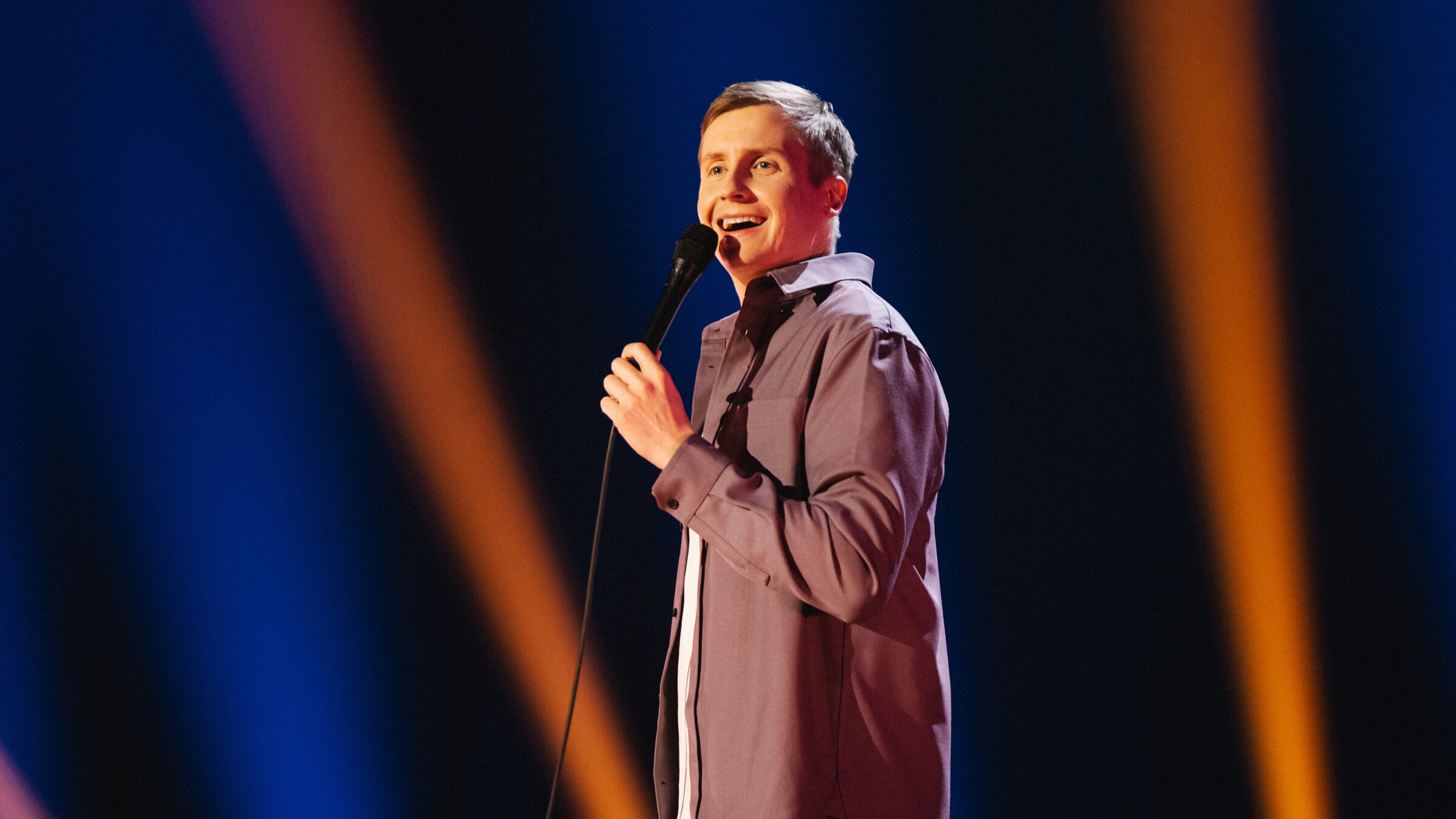 "Till Reiners: Mein Italien": Der Stand-Up-Comedian Till Reiners steht auf der Bühne und spricht zum Publikum. In der Hand hält er ein Mikrofon.