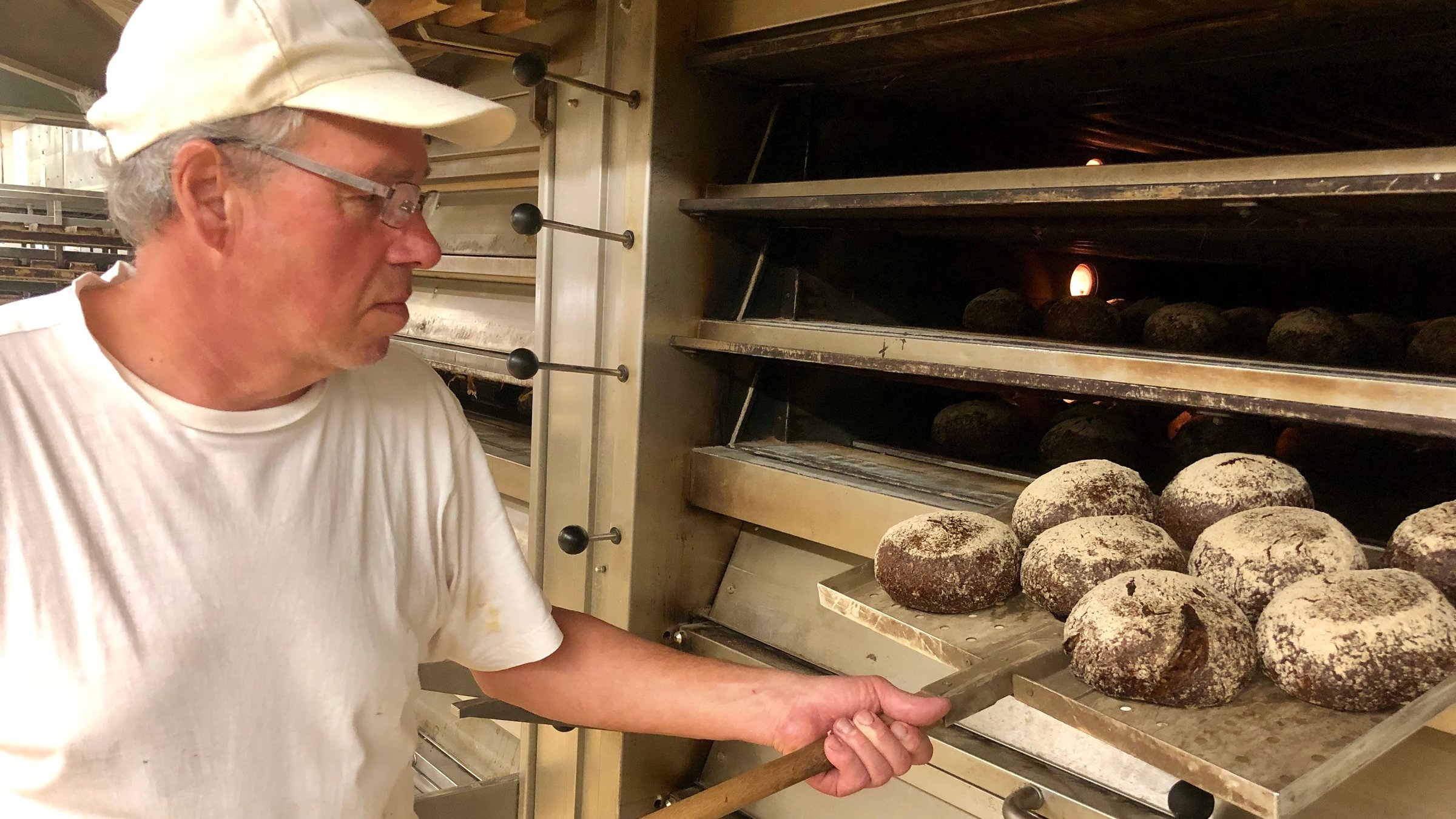 "ZDF.reportage Reicht die Rente? - Was vom Arbeitsleben übrig bleibt": Die Bäckerei Hinkel in Düsseldorf. Günther D. schiebt Brote in einen Ofen.