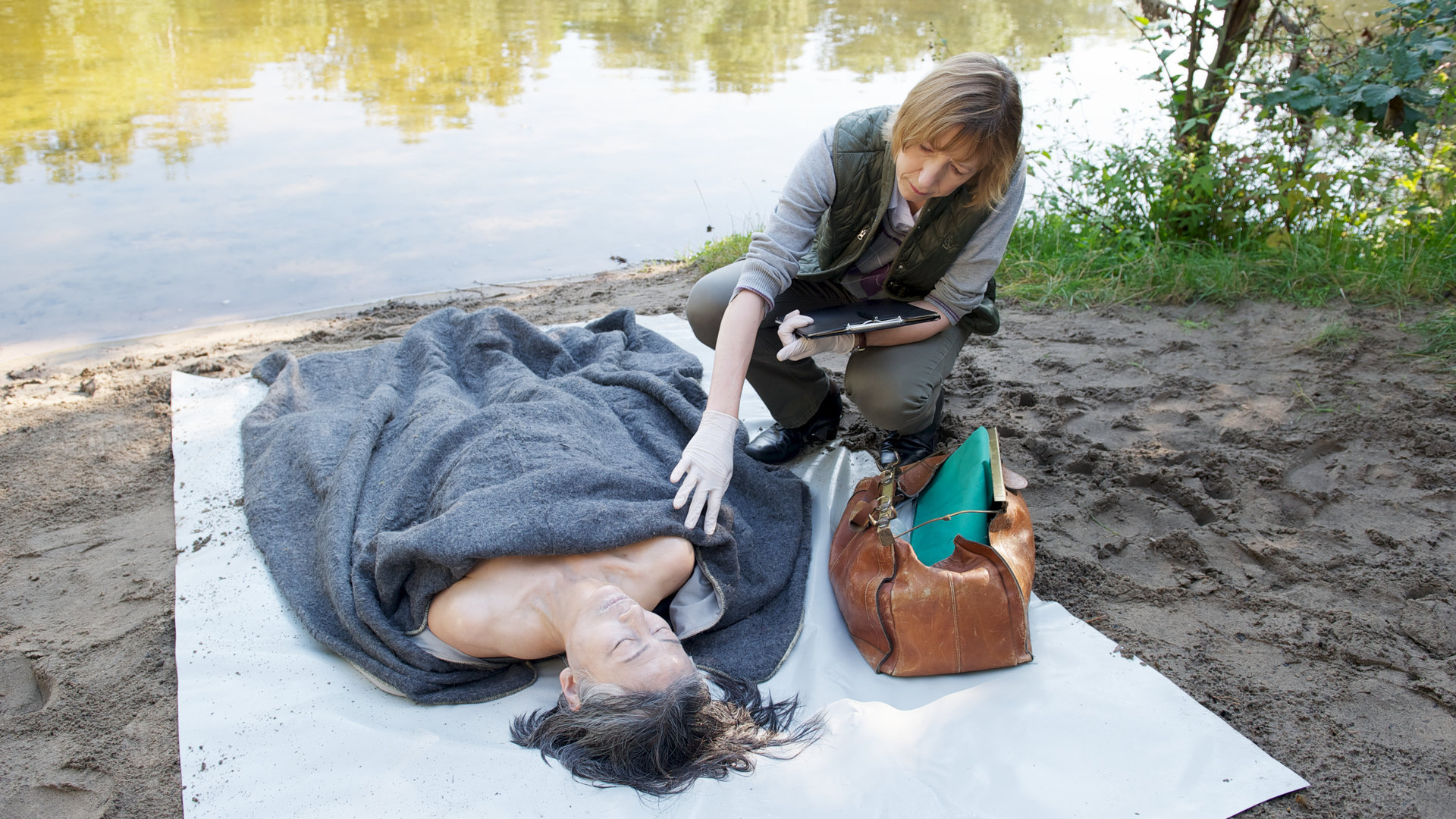 "SOKO Wismar - Die Fremde": Auf einer Decke an einem See liegt die Leiche einer Frau (Masumi Fukuchi). Katharina Sturbeck (Katharina Blaschke) untersucht sie.