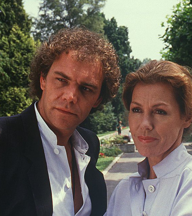 "Die Schwarzwaldklinik - Familienleben": Christa (Gaby Dohm ) und Dr. Vollmers (Christian Kohlund) stehen nebeneinander an einer Uferpromenade und blicken nachdenklich.