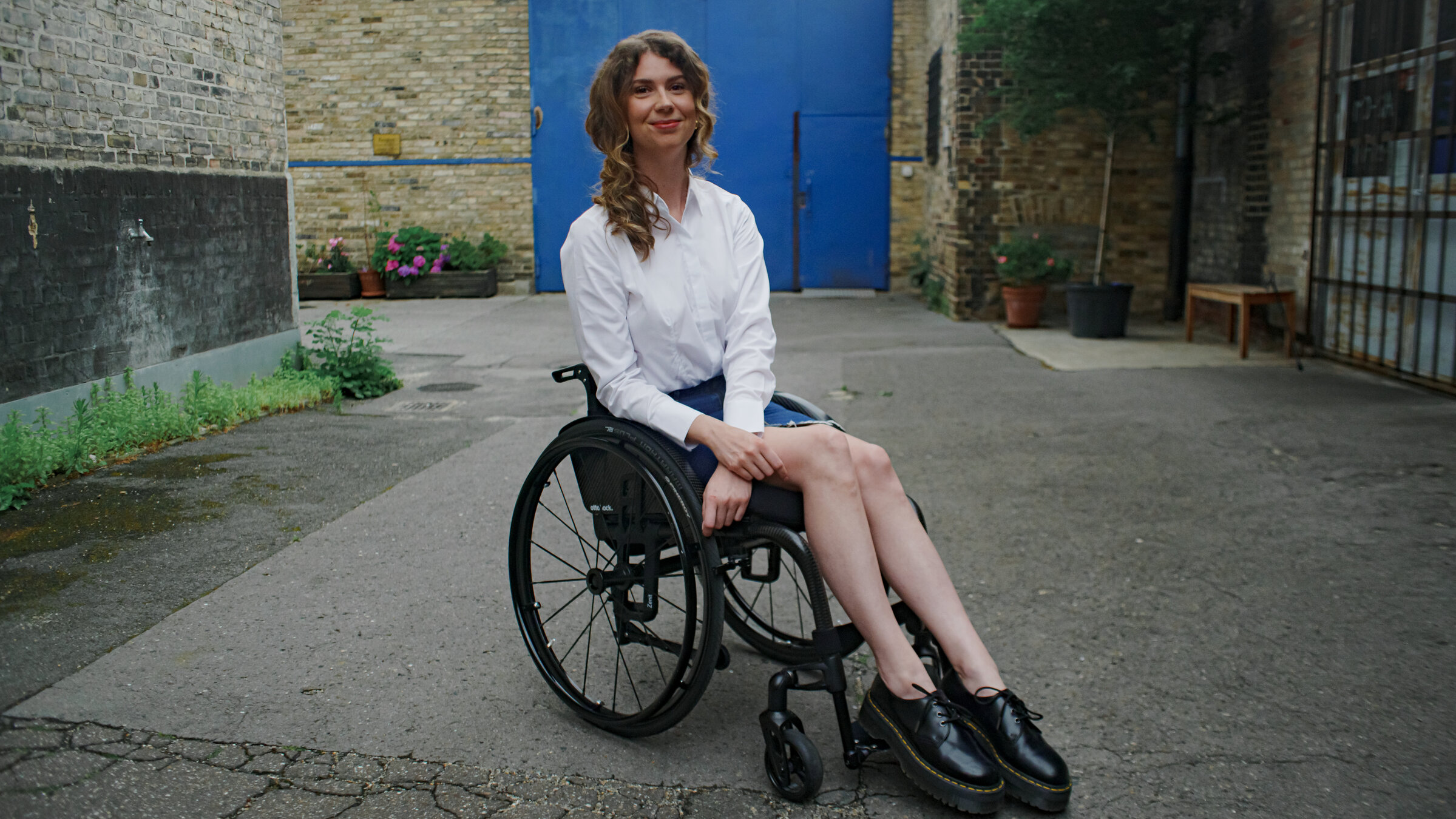 "einfach Mensch - Ayleen Walter: Barrierefrei schön (3)": Ayleen Walter sitzt in ihrem Rollstuhl vor dem Set eines Fotoshootings.