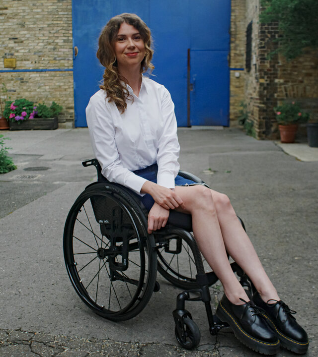 "einfach Mensch - Ayleen Walter: Barrierefrei schön (3)": Ayleen Walter sitzt in ihrem Rollstuhl vor dem Set eines Fotoshootings.