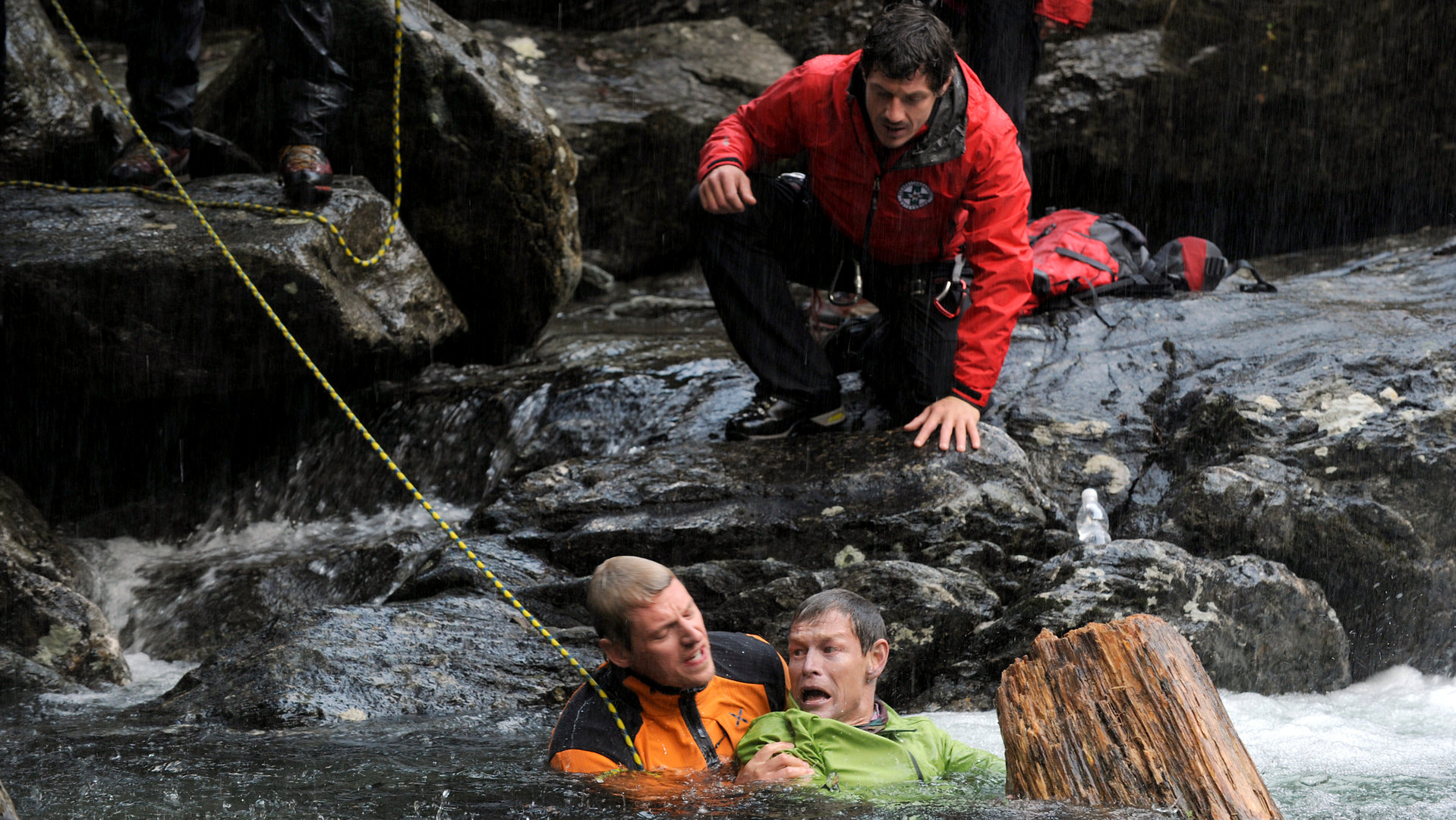 "Die Bergretter - Jetzt oder nie": Andreas (Martin Gruber) und Thomas (Steffen Wink) sind im Wasser. Andreas hält Thomas am Arm fest. Über ihnen, auf einem Fels, kniet Tobias (Markus Brandl).