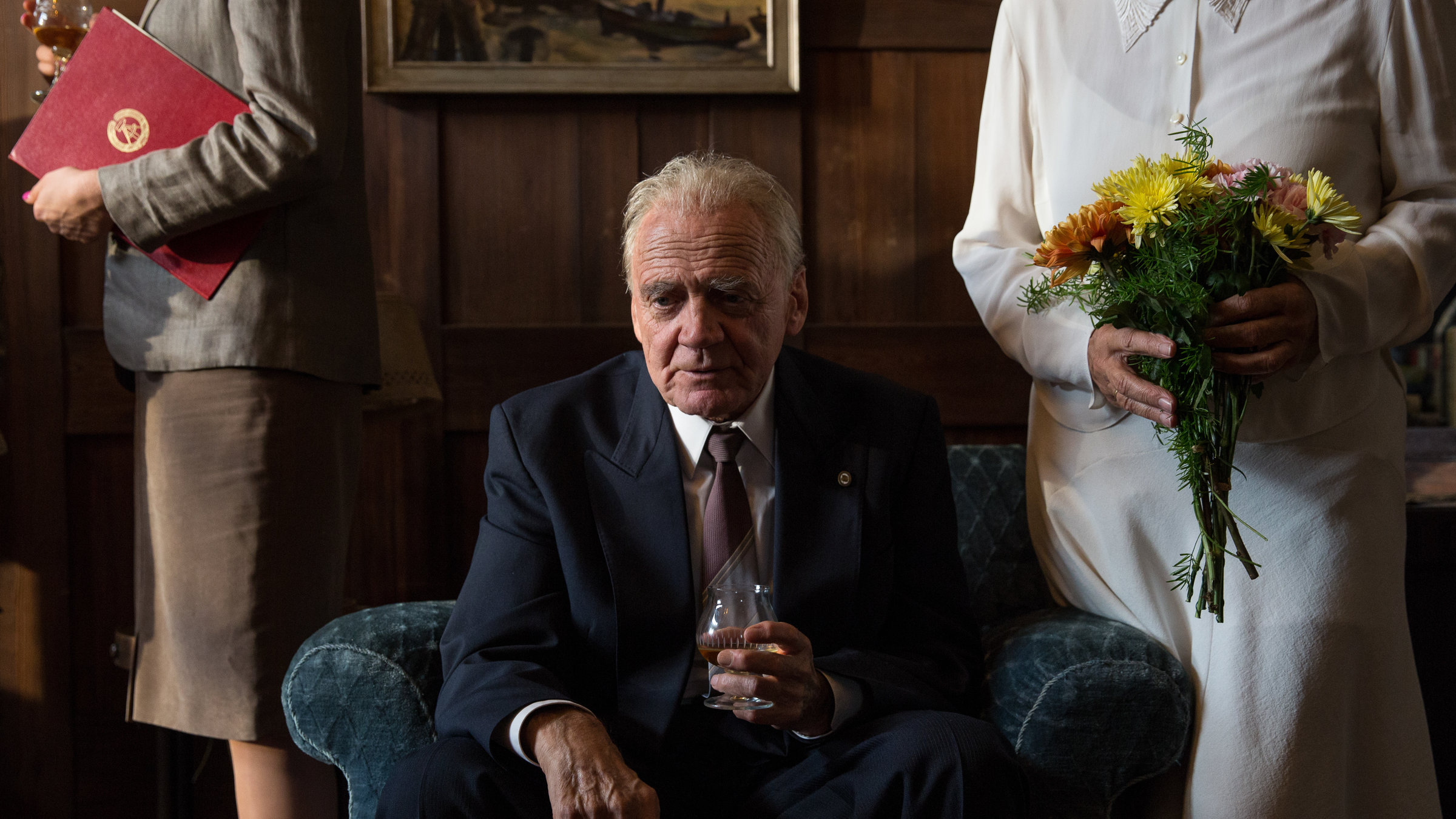 "In Zeiten des abnehmenden Lichts": Wilhelm Powileit (Bruno Ganz) sitzt im schicken Anzug auf einem Sessel, mit einem Getränk in der Hand.
