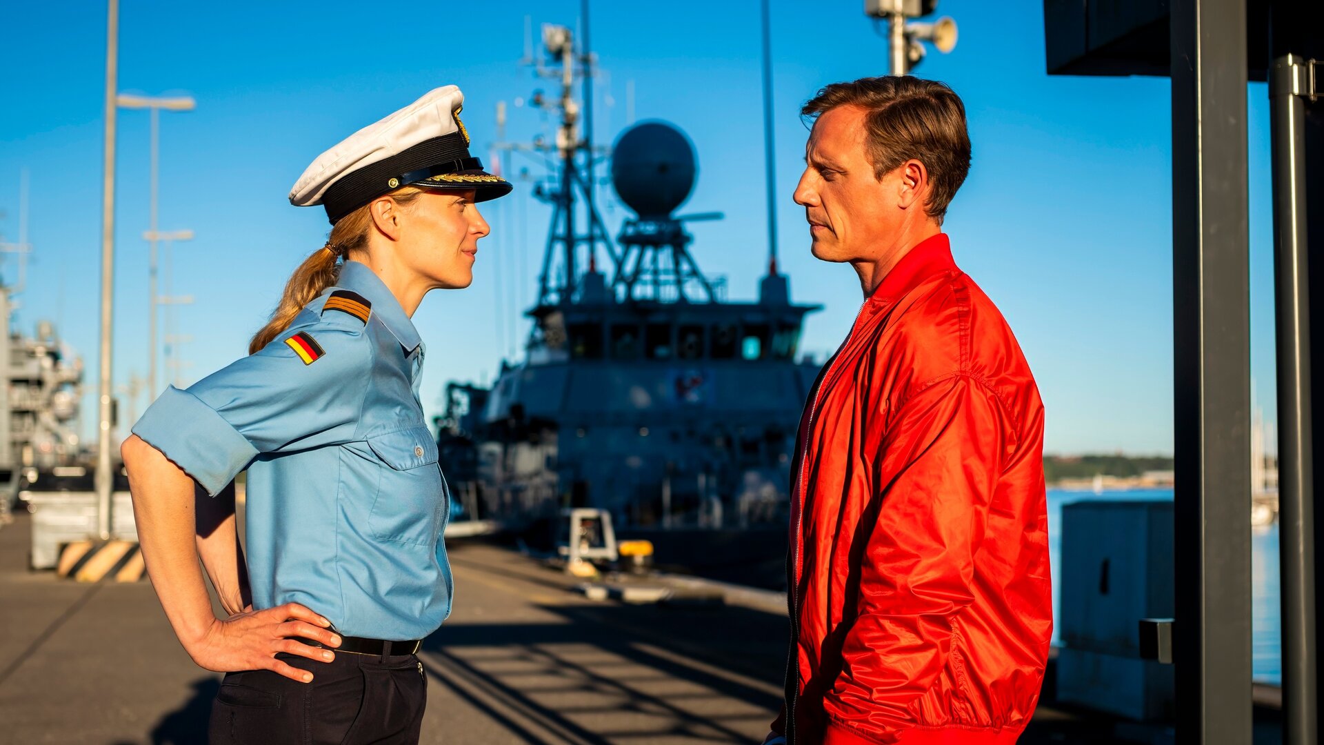 "Dr. Nice - SchiffbrÃ¼chig": Im Hafen steht die Marineoffizierin Miriam Nicolai (Franziska Junge) Dr. Nice (Patrick Kalupa) gegenÃ¼ber. Sie hat ihre HÃ¤nde in die HÃ¼ften gestemmt.
