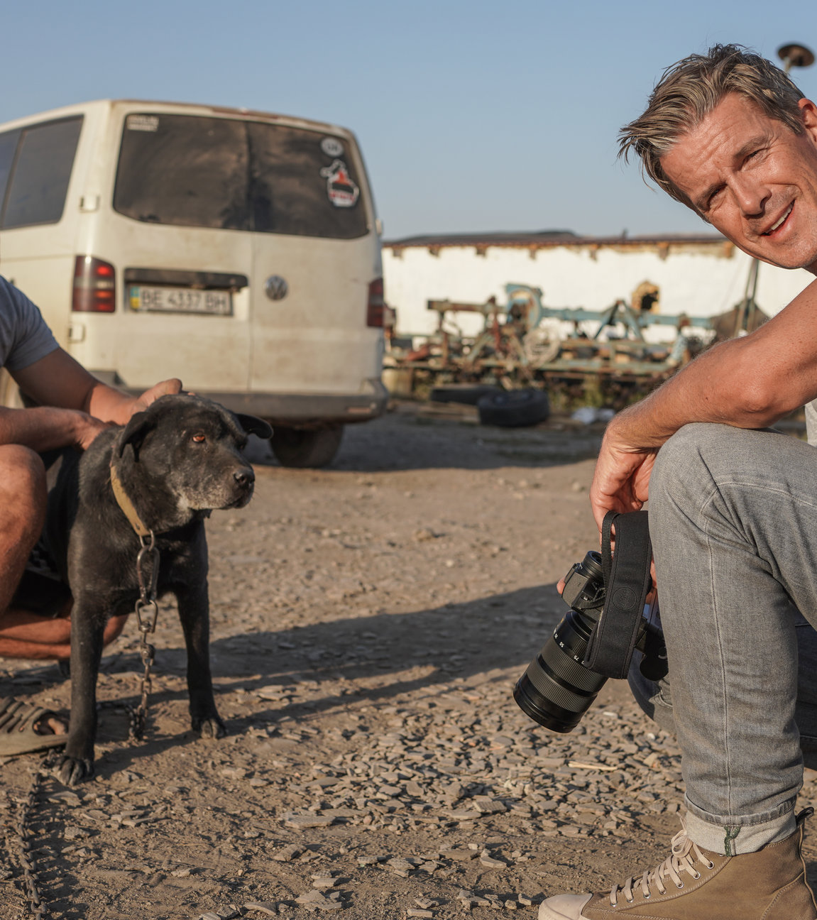 "Markus Lanz: Ukraine - Leben mit dem Krieg": Der Bauer Vitaliy und Markus Lanz sitzen in der Hocke auf einer Straße. Vitaliy streichelt seinen Hund, während Markus Lanz in die Kamera sieht.