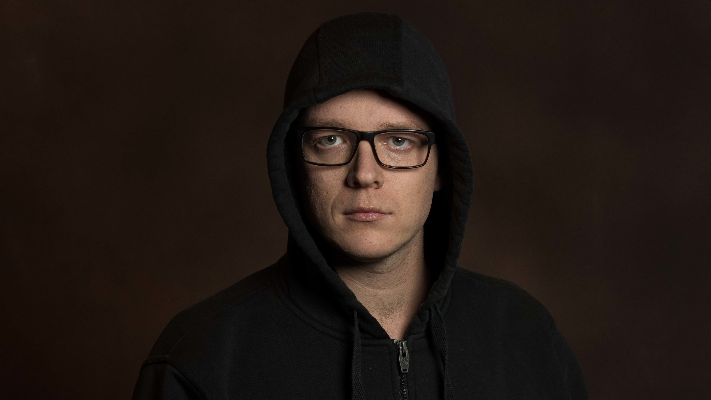 "Nico Semsrott: Freude ist nur ein Mangel an Information 2017": Nico Semsrott trägt eine schwarze Jacke mit Kapuze. Die Kapuze ist über seinem Kopf. Er schaut ernst in die Kamera.