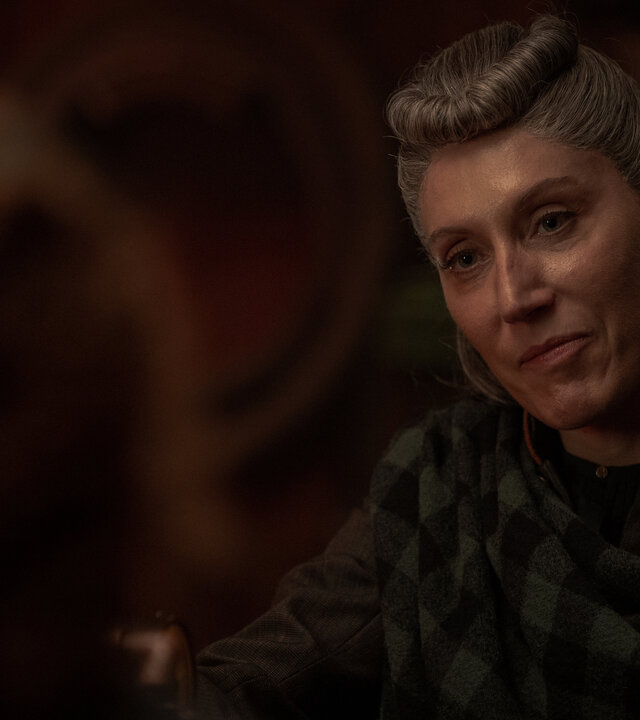 "Nautilus - Am Abgrund": Loti (Céline Menville) befindet sich in einem dunklen Raum. Sie blickt ihr Gegenüber an. Im Vordergrund ist unscharf der Hinterkopf von Humility (Georgia Flood) zu erkennen.