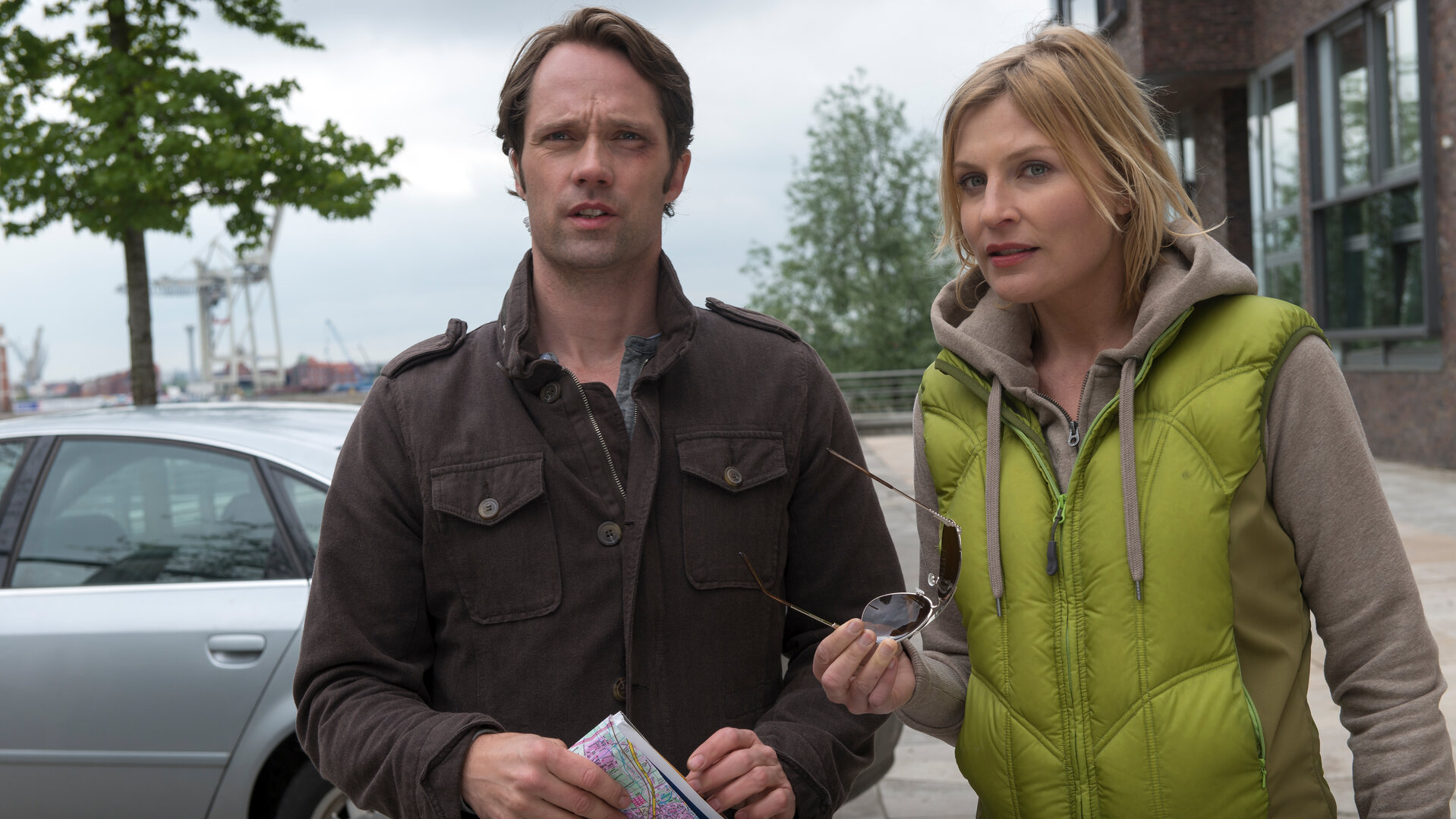 "Notruf Hafenkante: Das fremde Kind": Melanie (Sana Englund) und Mattes (Matthias Schloo) stehen vor einem Gebäude nebeneinander und schauen in die Ferne.